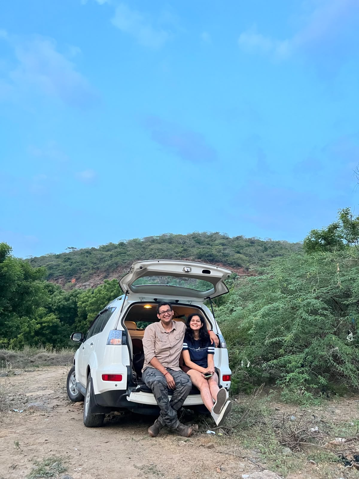 Simran and Varun sitting together at the back of a car on a road trip